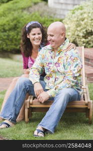Mature couple sitting on a lounge chair and smiling