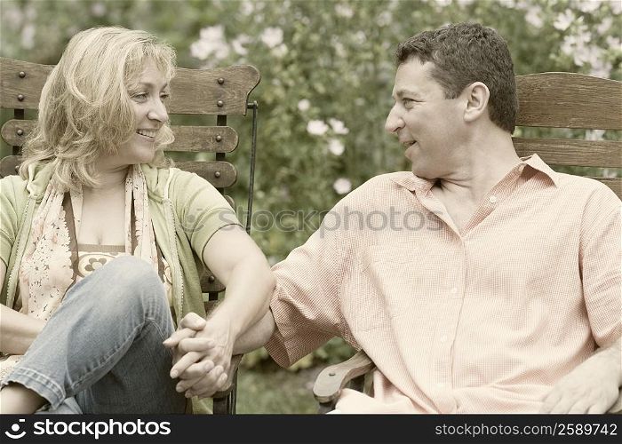 Mature couple sitting on chairs and holding each other&acute;s hands