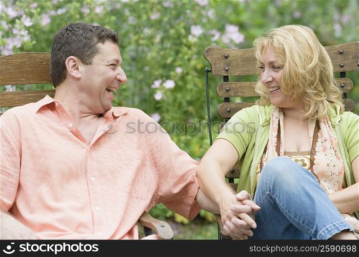 Mature couple sitting on chairs and holding each other&acute;s hands