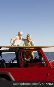 Mature couple smiling in a sports utility vehicle