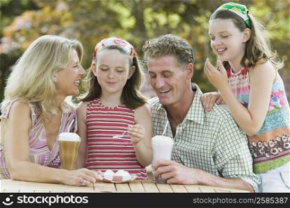 Mature couple smiling with their two daughters