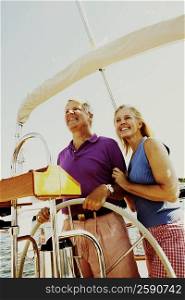 Mature couple standing in a boat and smiling