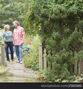 Mature couple standing in a garden and looking at each other