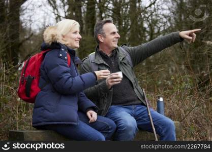 Mature Couple Stop For Rest And Hot Drink On Walk Through Fall Or Winter Countryside