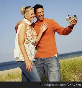 Mature couple taking a picture of themselves on the beach