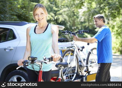 Mature Couple Taking Mountain Bikes From Rack On Car