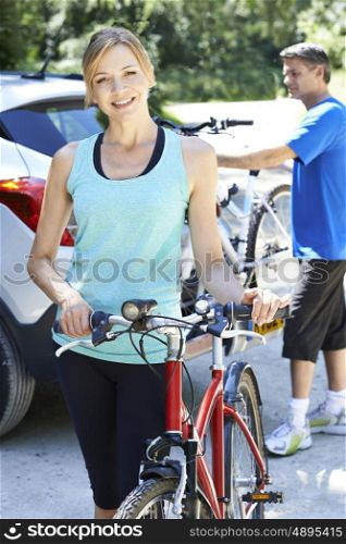 Mature Couple Taking Mountain Bikes From Rack On Car