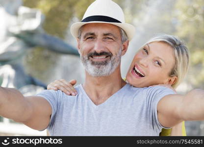 mature couple taking selfie outdoors with smart phone