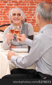 Mature couple toasting with rose wine