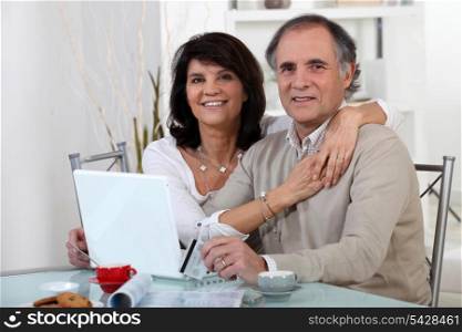 Mature couple using a credit card online