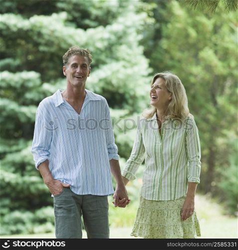 Mature couple walking in a lawn and smiling