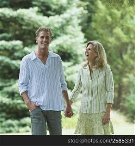 Mature couple walking in a lawn and smiling