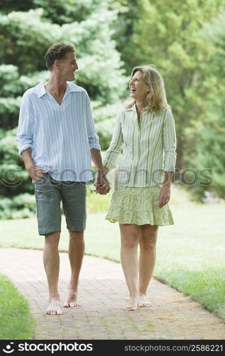 Mature couple walking in a lawn and smiling