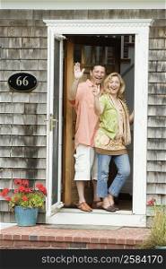 Mature couple waving their hands at the door