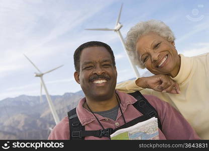 Mature couple with map by wind farm