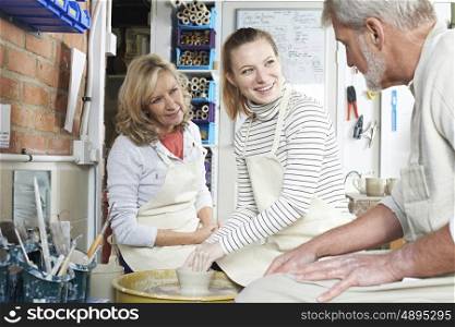 Mature Couple With Teacher In Pottery Class