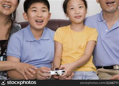 Mature couple with their children playing video game