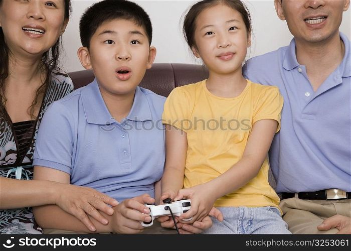 Mature couple with their children playing video game