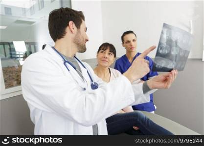 mature doctor in office looking at xray results