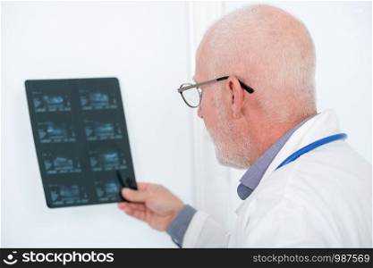 mature doctor looking at an x-ray in an office