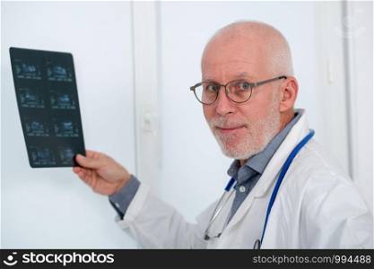 mature Doctor looking at an x-ray in an office