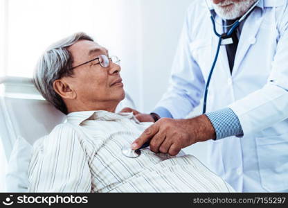 Mature doctor talking and examining health of senior patient in hospital ward. Medical healthcare and doctor staff service concept.