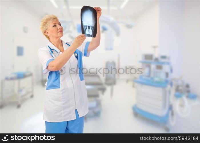 Mature doctor with x-ray at medical office
