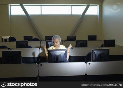 Mature female student working in computer classroom