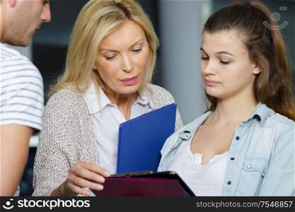 mature female teacher helping teenage student