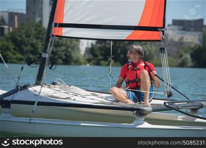 mature handsome man sailing on a lake