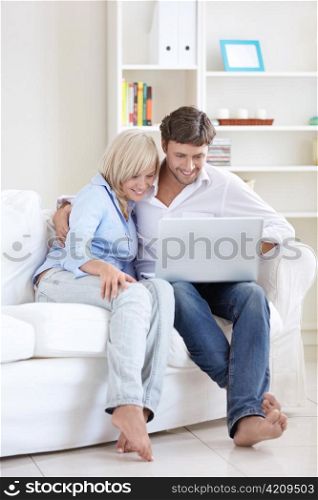 Mature happy couple with laptop at home