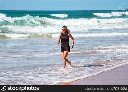 Mature healthty woman running at the beach
