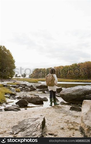 Mature hiker walking over rocks