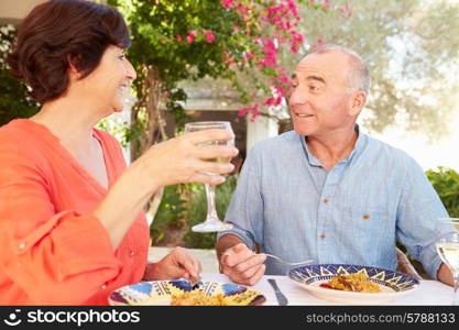 Mature Hispanic Couple Enjoying Outdoor Meal At Home