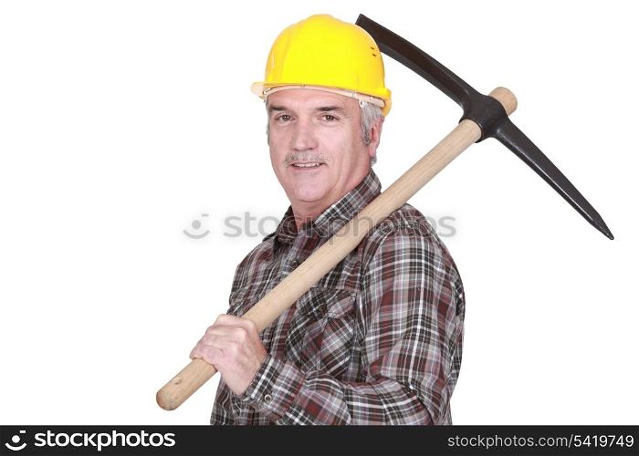 Mature laborer carrying a pickaxe on his shoulder