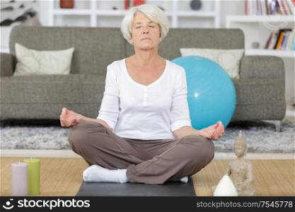 mature lady doing yoga at home
