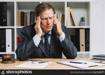 mature lawyer with headache sitting courtroom