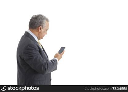 Mature male executive text messaging on white background