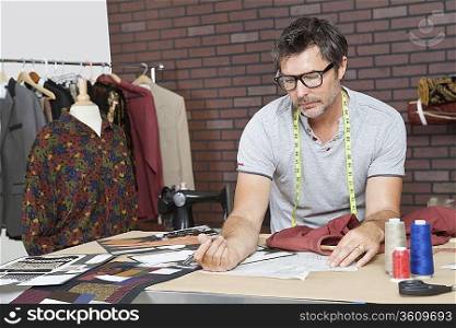 Mature male fashion designer working in design studio