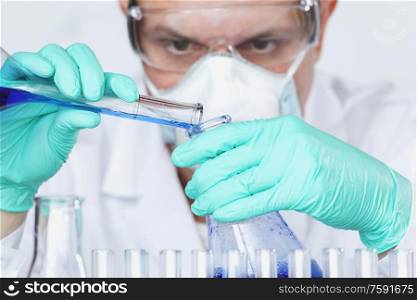 Mature male researcher carrying out scientific research in a lab, Chemistry experiments close up. Scientist carrying out scientific research