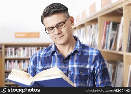Mature Male Student Studying In Library