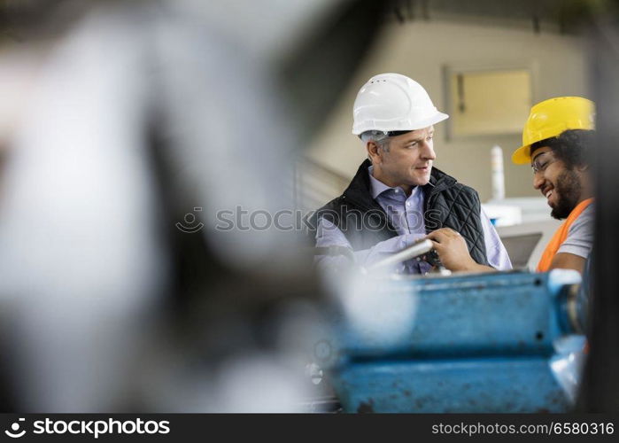 Mature male supervisor talking with worker in metal industry