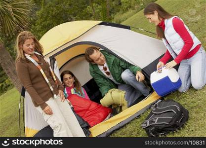 Mature man and a mid adult woman camping with their two daughters