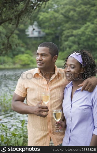 Mature man and a mid adult woman holding glasses of wine and smiling