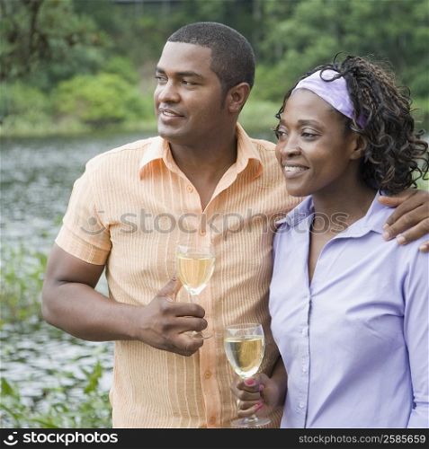 Mature man and a mid adult woman holding glasses of wine and smiling