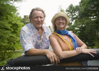 Mature man and a mid adult woman in a convertible car and smiling
