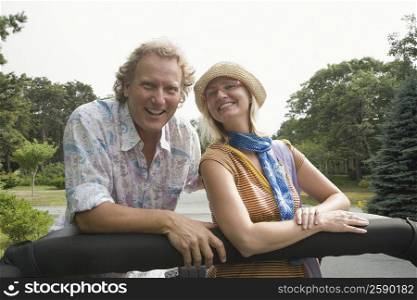 Mature man and a mid adult woman in a convertible car and smiling
