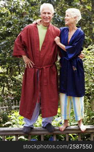 mature man and a senior woman standing on a railing and smiling