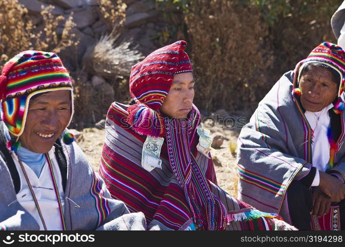 Mature man and a young man sitting with a groom, Taquile Island, Lake Titicaca, Puno, Peru