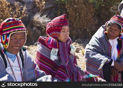 Mature man and a young man sitting with a groom, Taquile Island, Lake Titicaca, Puno, Peru
